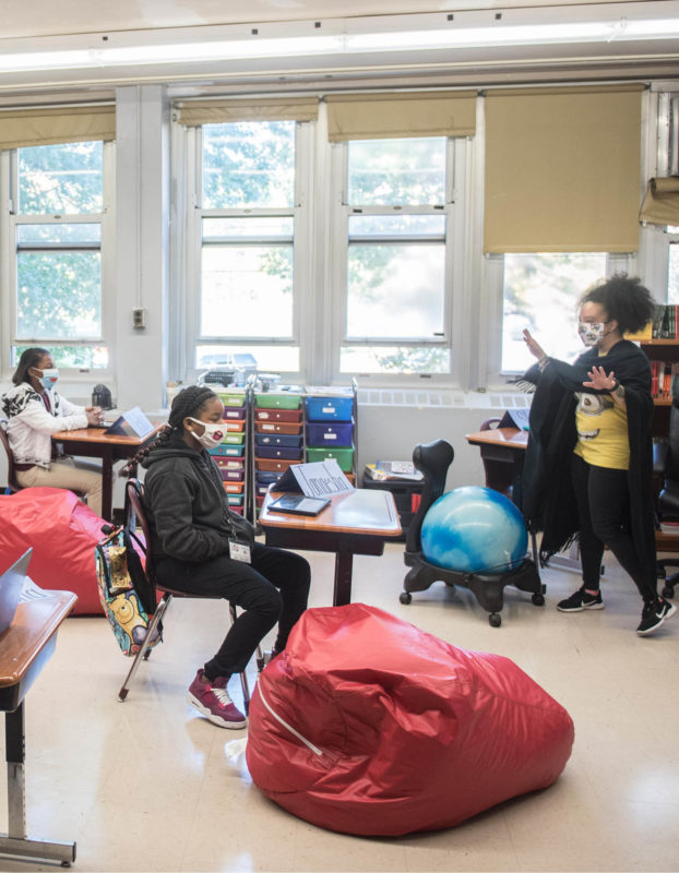 Teacher surrounded by students in New York City classroom